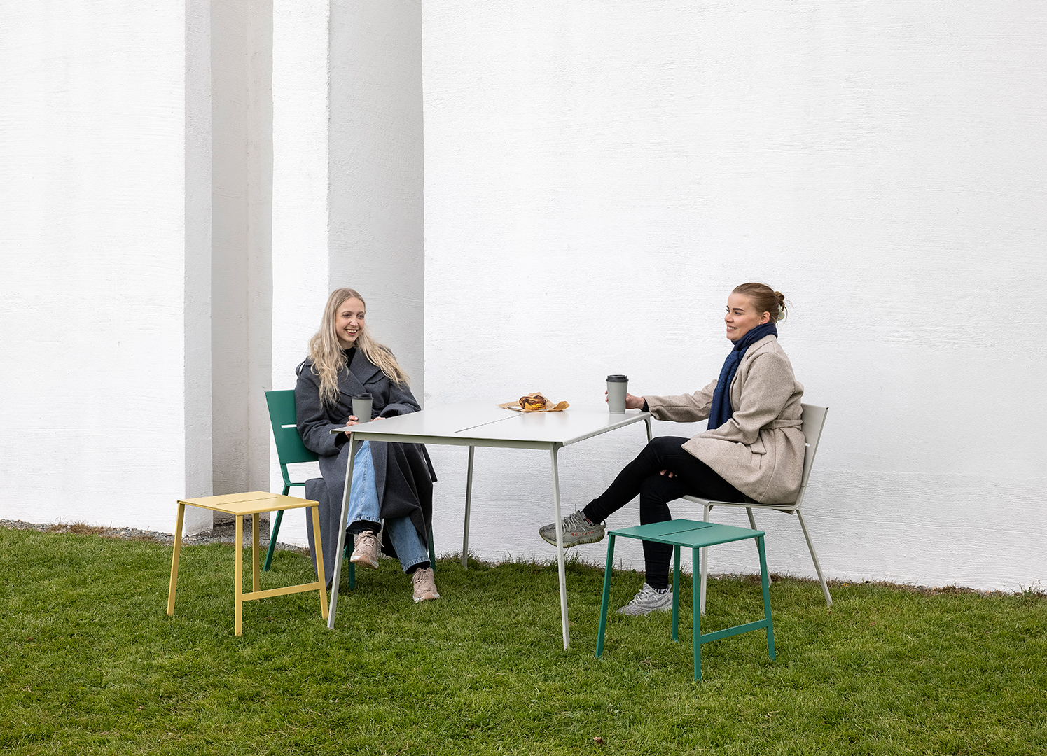 TERÄS steel table with chairs in different colours on a lawn