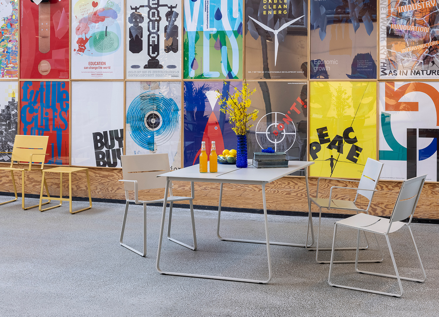 Steel furniture in front of a wall of posters