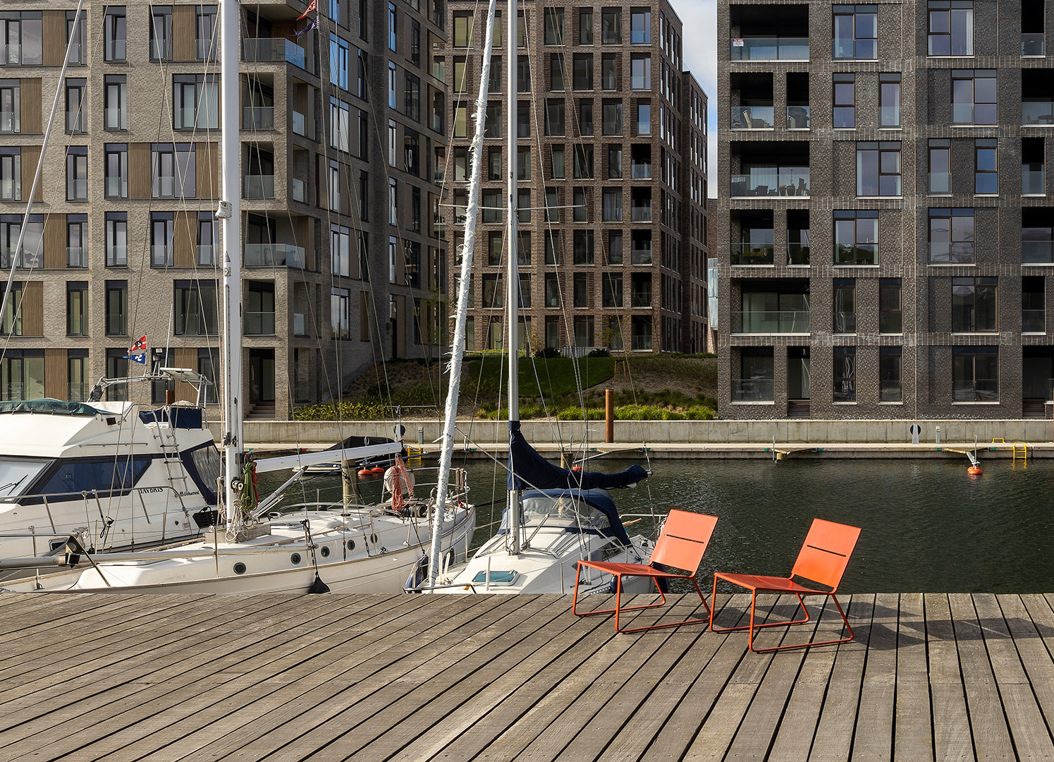 Orange lounge chairs in modern Danish design seen by the harbour