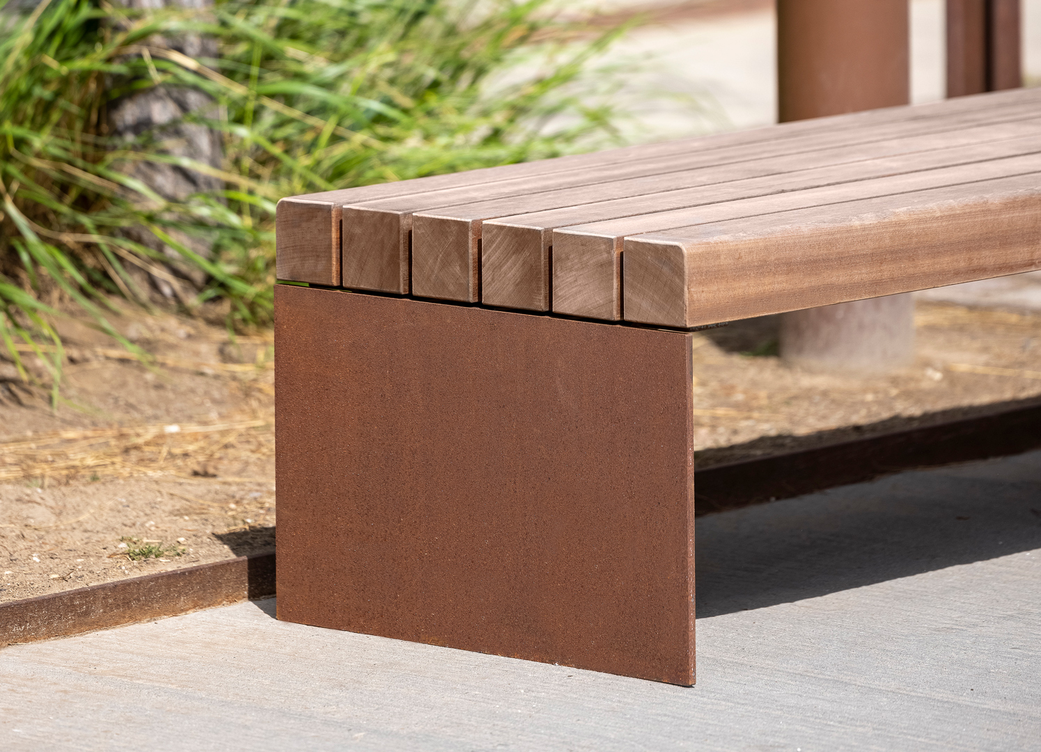 COSI bench with mahogany slats and corten steel ends is seen up close